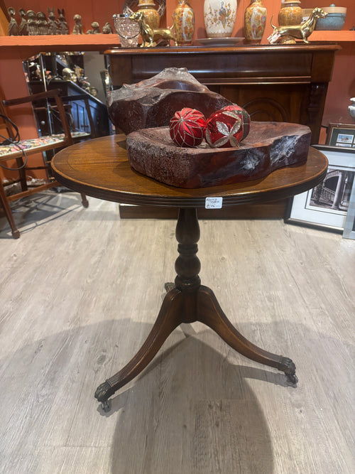Wooden side table with decorative items on a marble floor