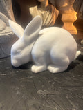 White ceramic rabbit figurine on a textured surface
