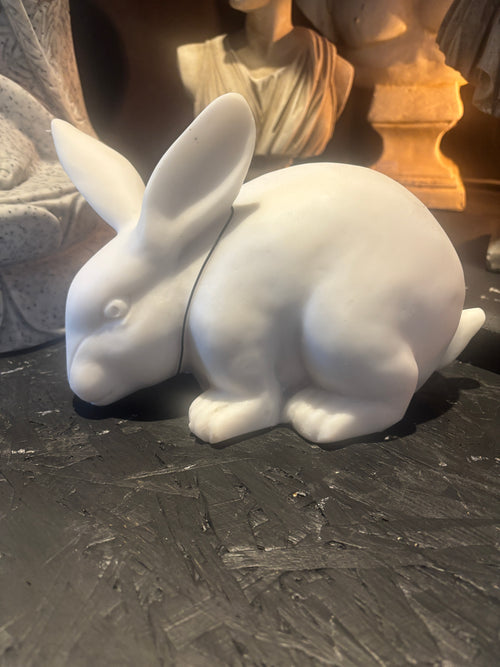 White ceramic rabbit figurine on a textured surface