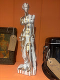 Statue of a lady with dripping gold paint standing on a shelf
