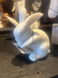 White ceramic Rabbit figurine with a label on a dark surface