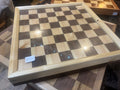 Wooden checkered game board on a wooden surface
