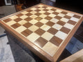 Wooden chessboard with checkered pattern on a table