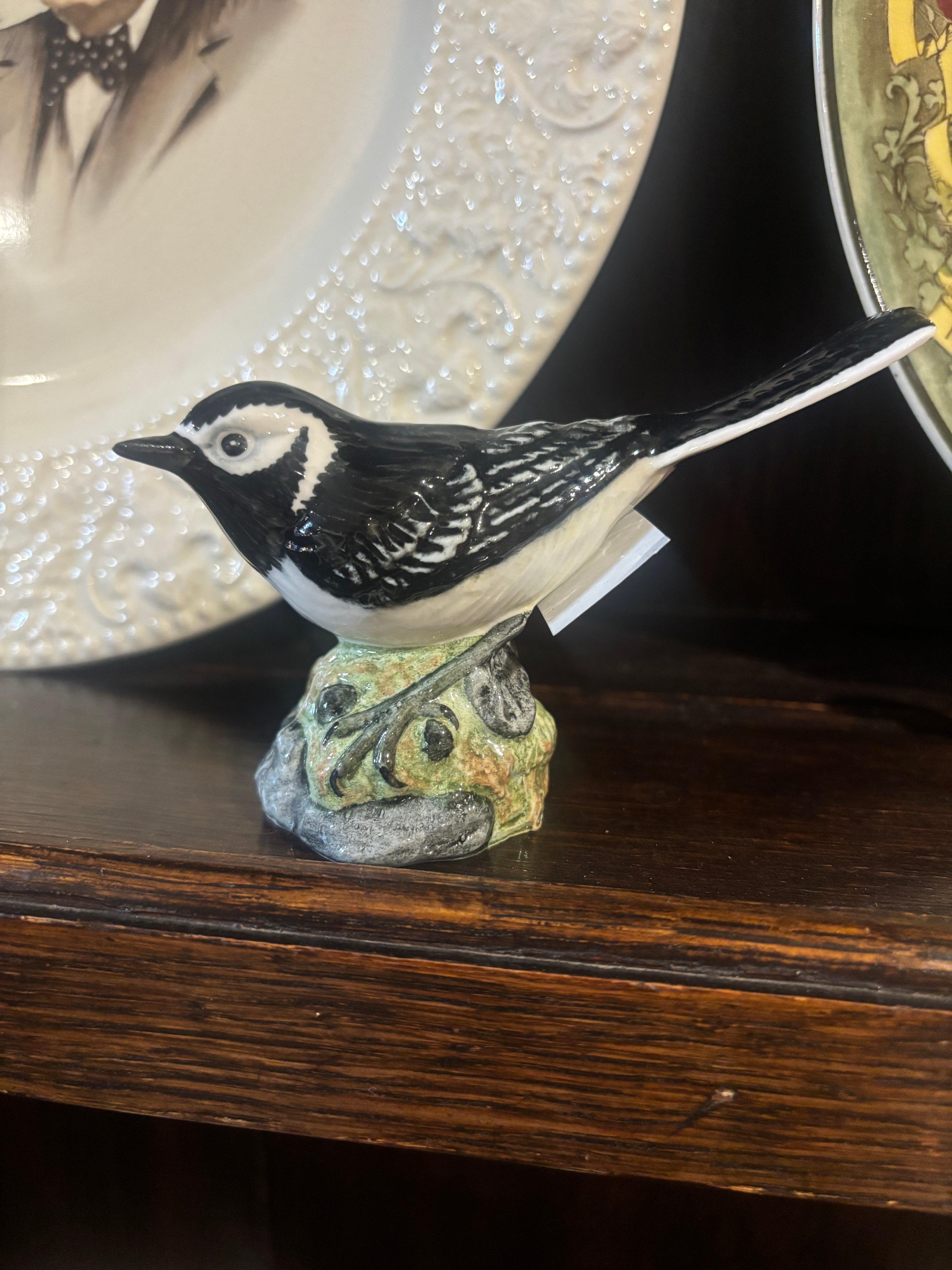 Decorative bird ornament on a wooden surface with a blurred background