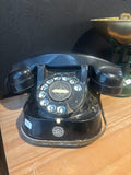 Black Bakelite Vintage Dial Telephone on a wooden surface